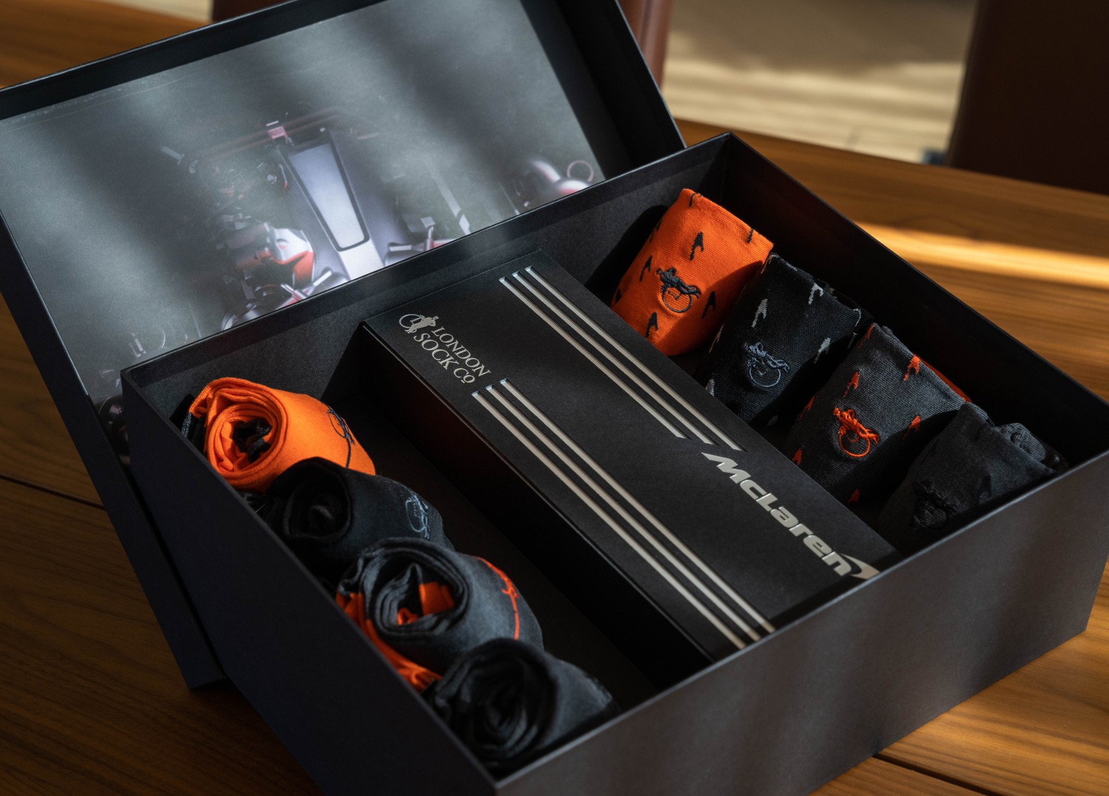 Eight socks in a box with Mclaren logos and orange colours
