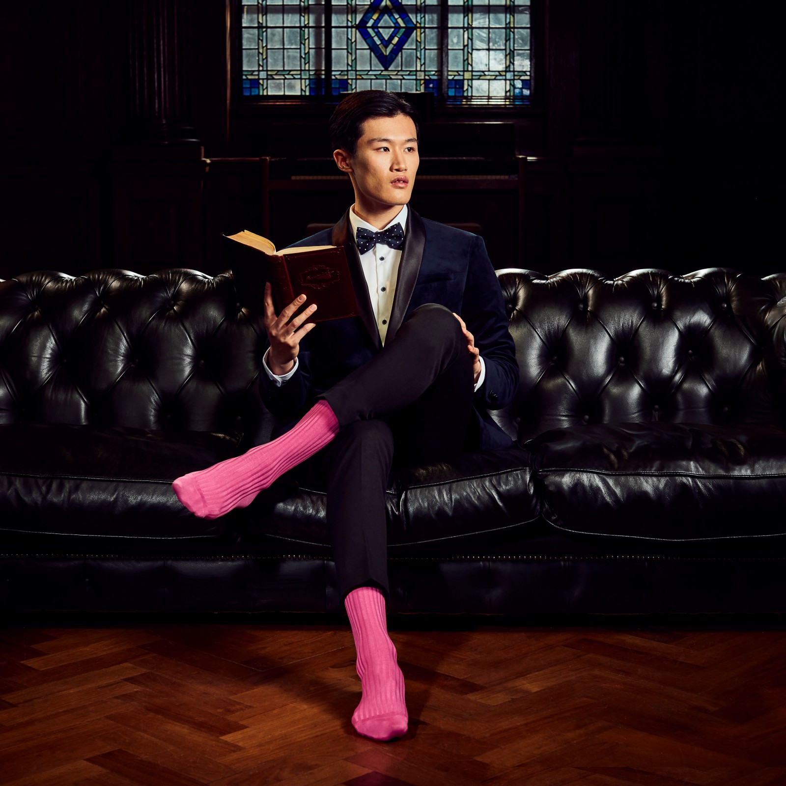 A man sitting on a sofa with bright pink socks