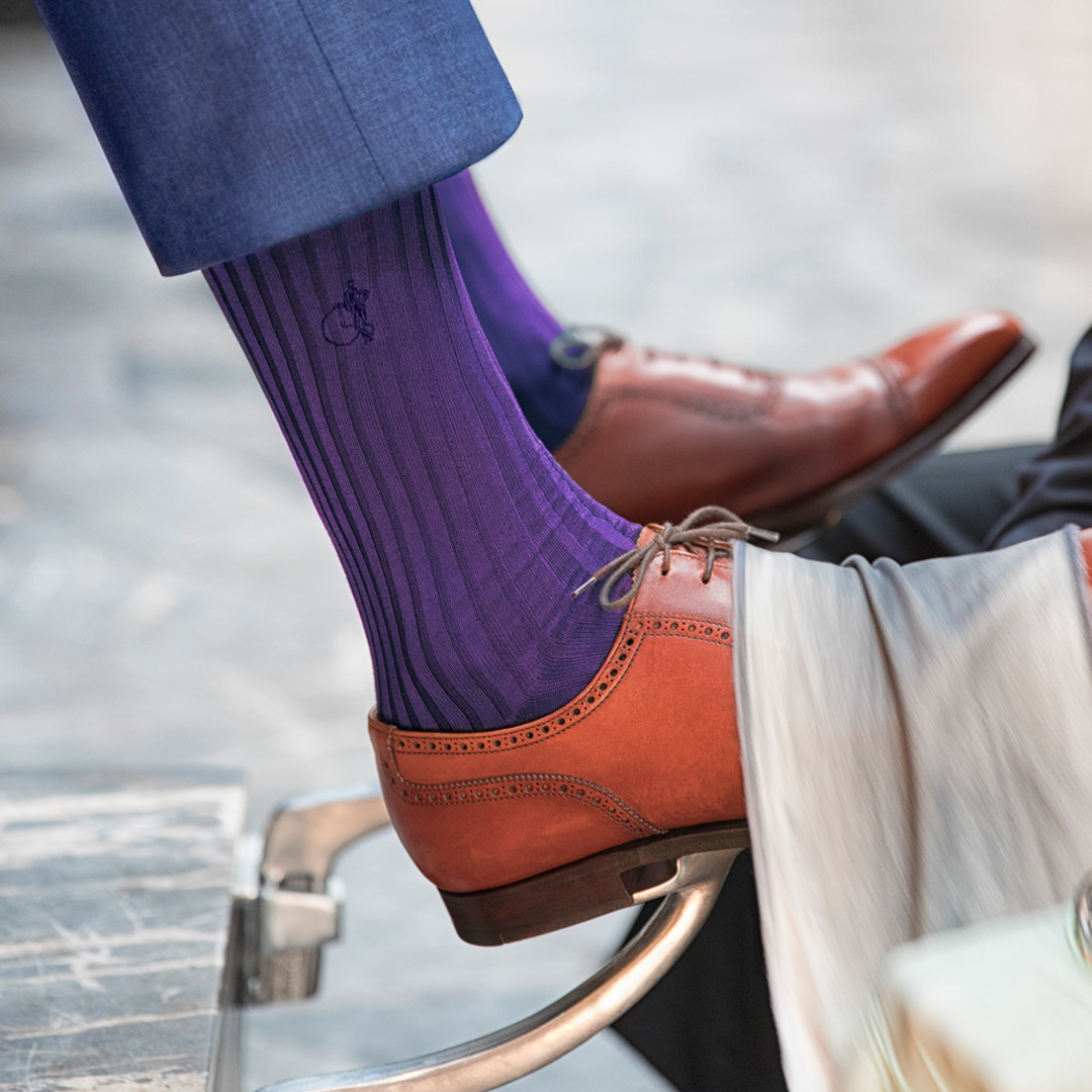 Man in purple socks by London Sock Company and brown brogues getting a shoe shine.
