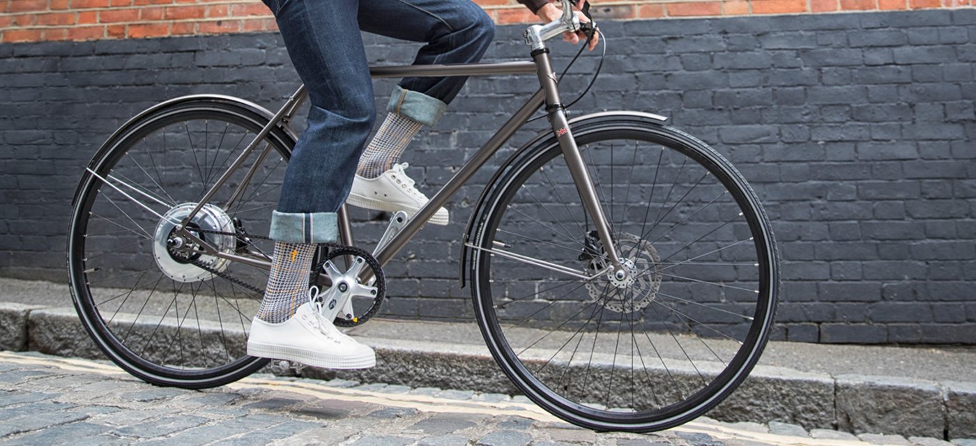Man on bike wearing jeans and Ottaway Grey socks from London Sock Company