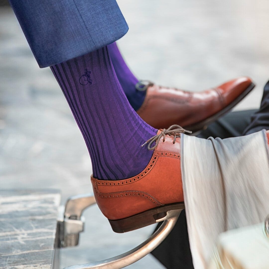 Man in purple socks and brown brogues getting a shoe shine.