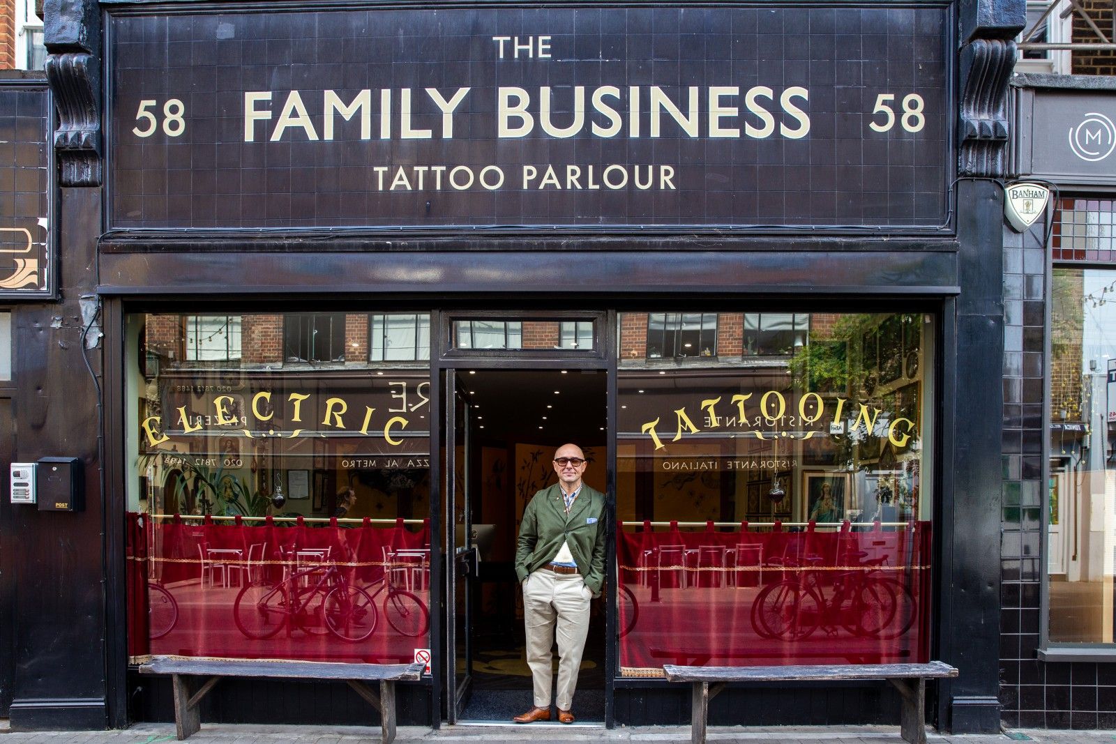 A man standing outside The Family Business tattoo parlour