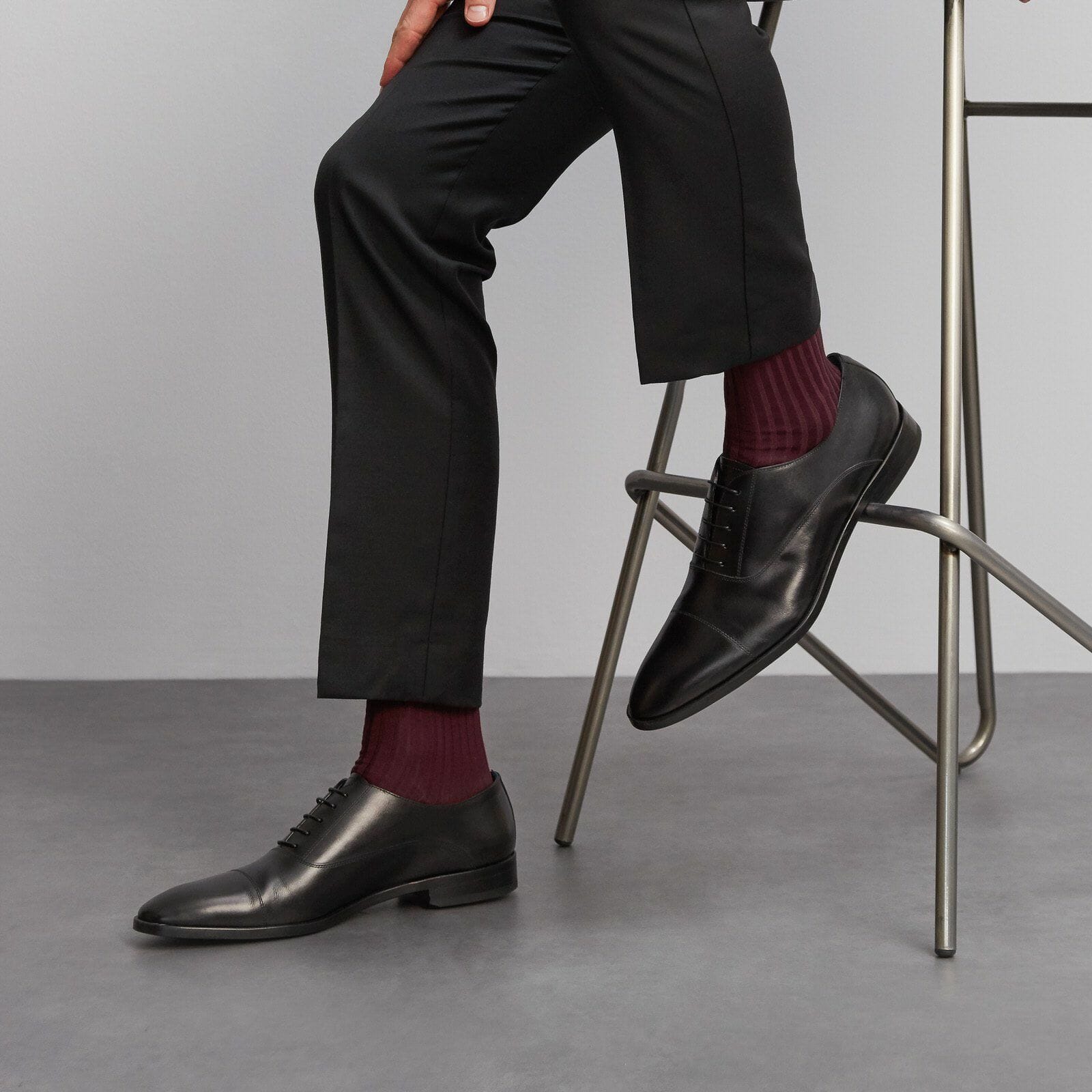 A man sitting down wearing burgundy socks