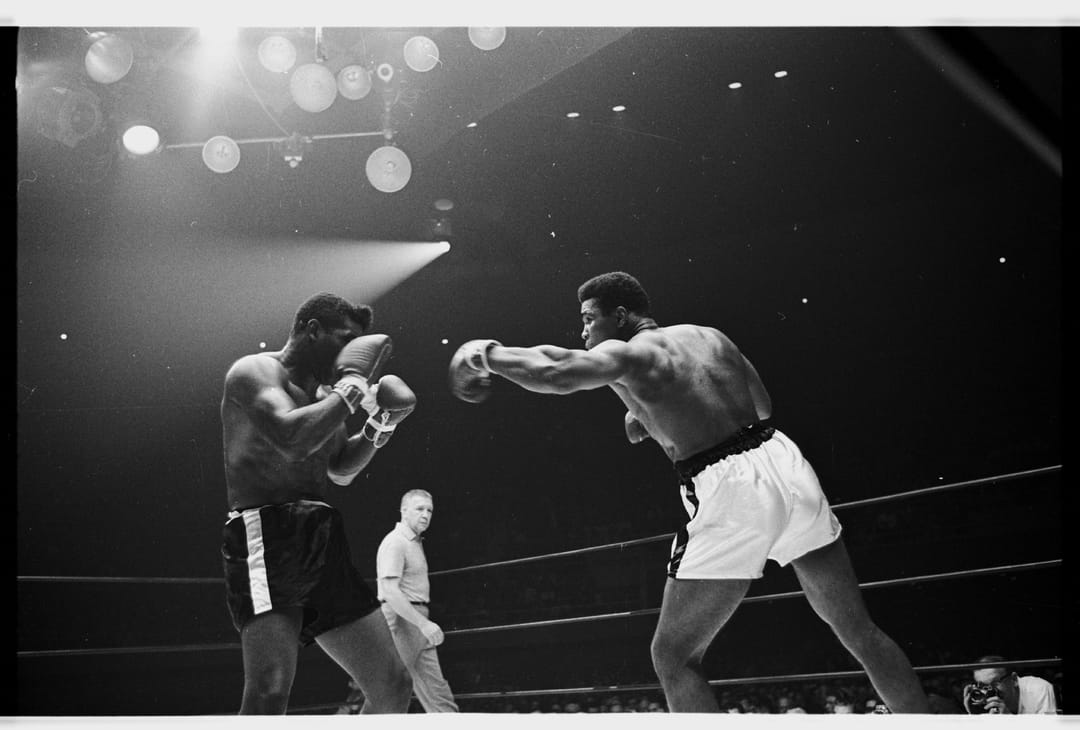 A black and white photo of Muhammad Ali in the boxing ring