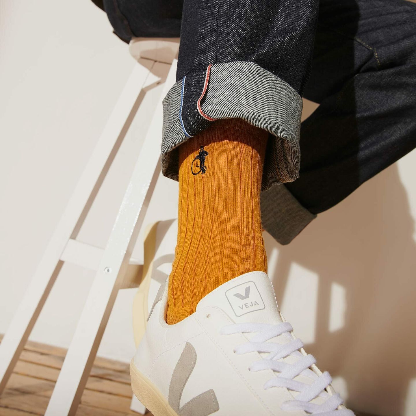 Close up of a mans ankle wearing saffron yellow socks and white trainers