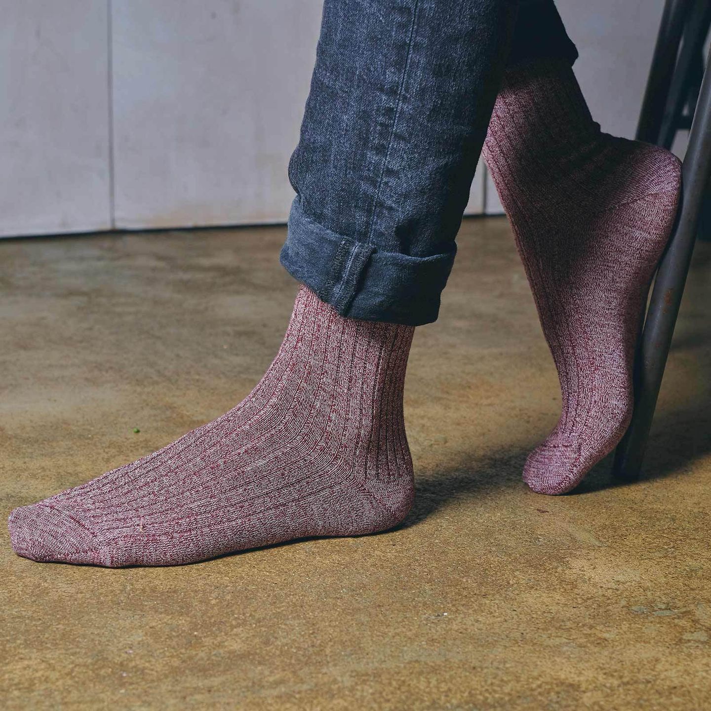 Man wearing marl socks in burgundy on a brown concrete floor
