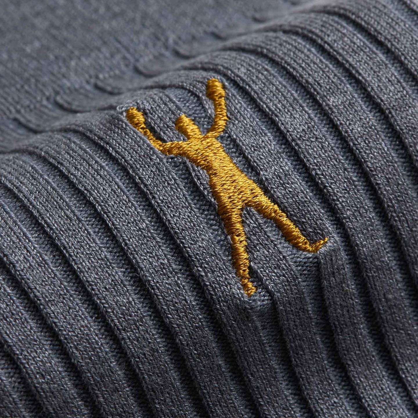 Close up of dark grey Muhammad Ali socks and gold logo