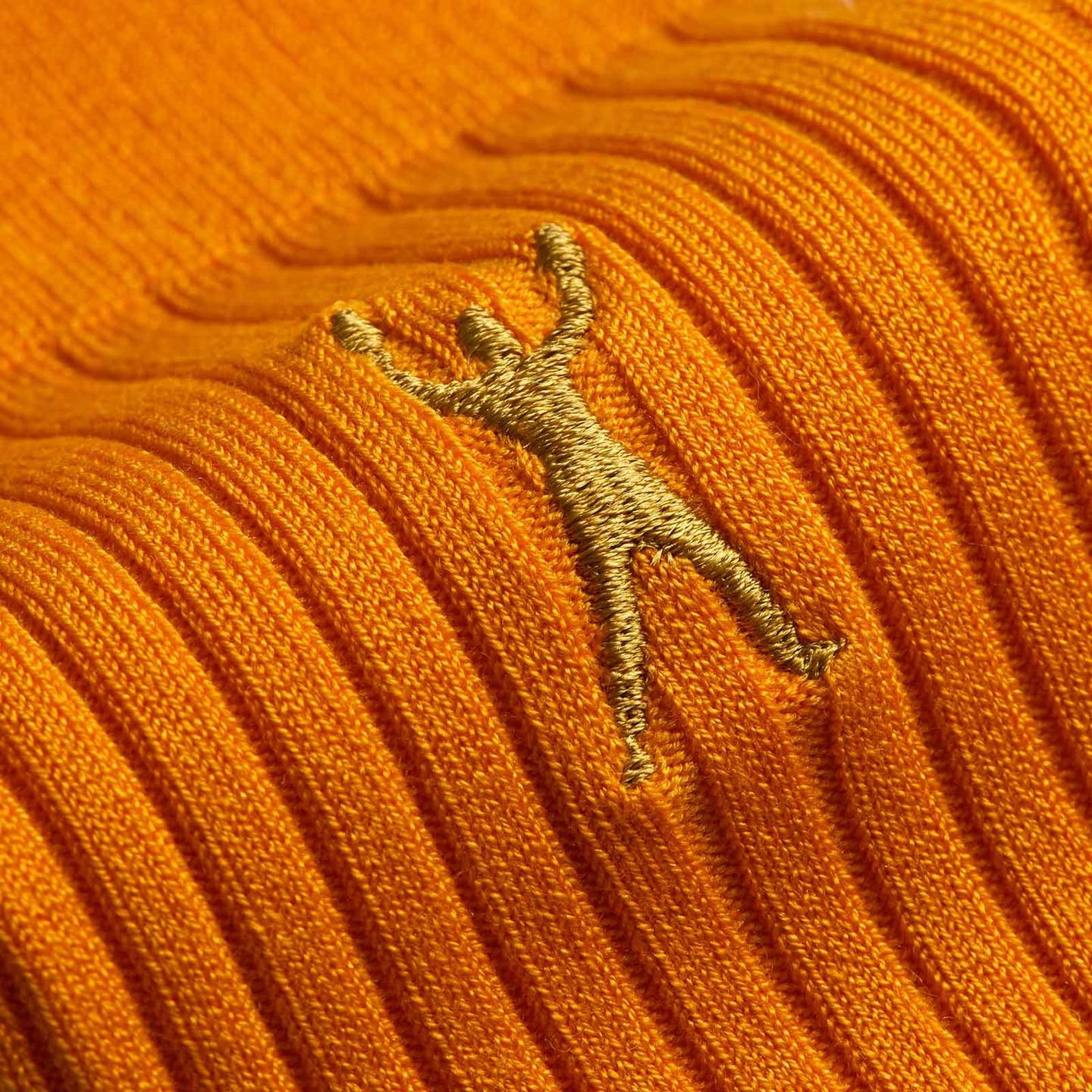 Close up of the gold logo on the saffron Muhammad Ali Collection sock