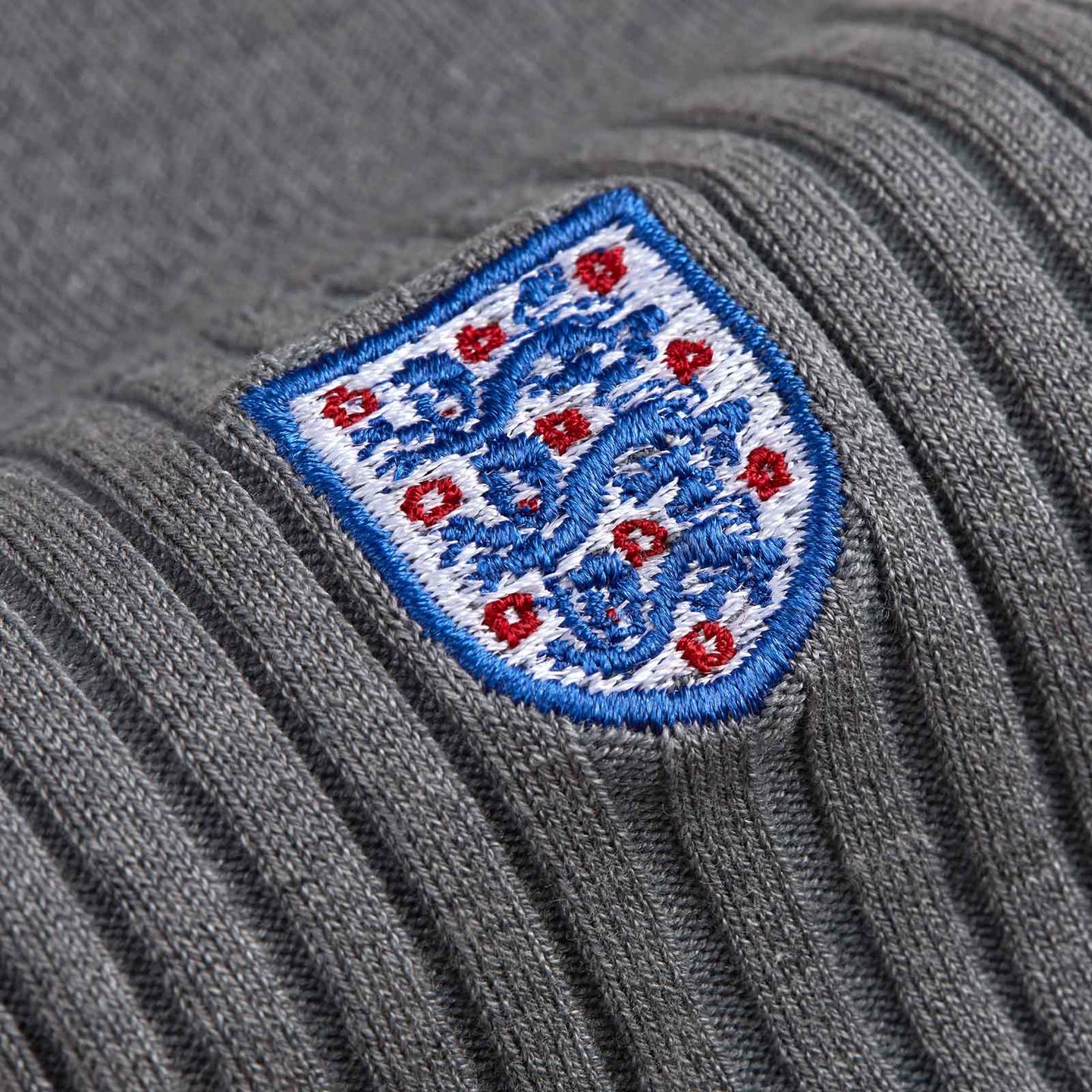 Close up of grey sock with the 3 lion embroidered logo