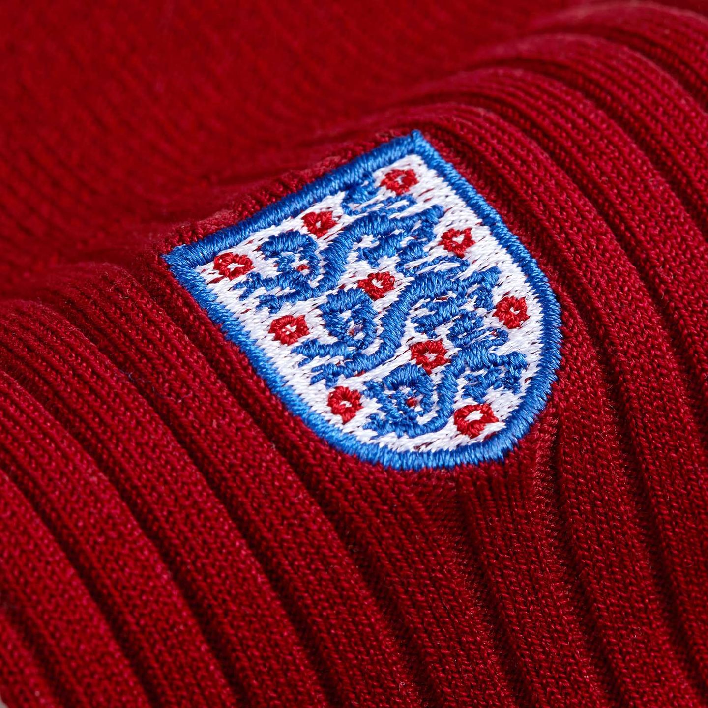 A close up of the England badge on a red sock
