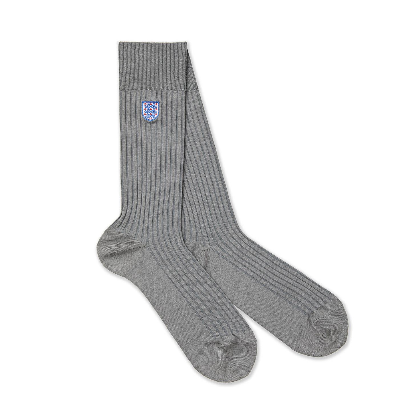 A pair of light grey socks with the England badge on them