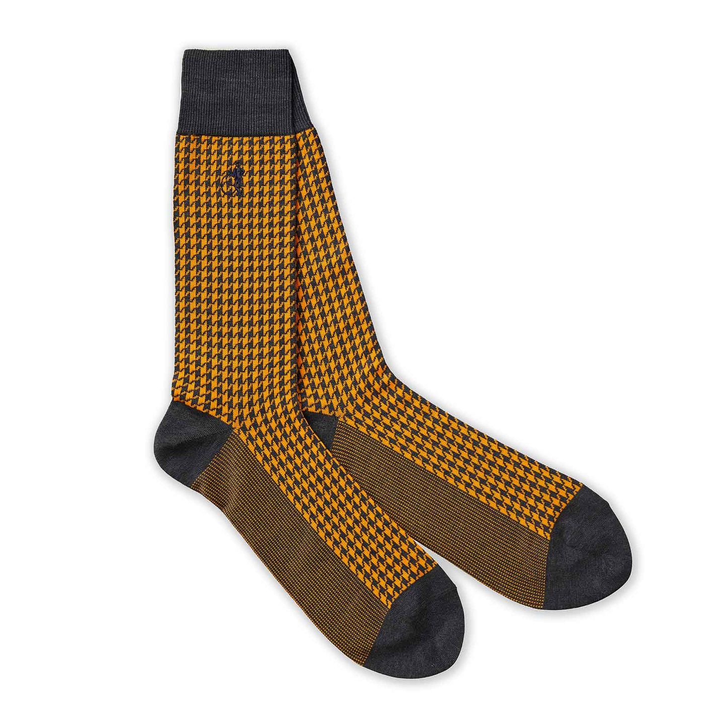 A pair of yellow patterned socks with a white background