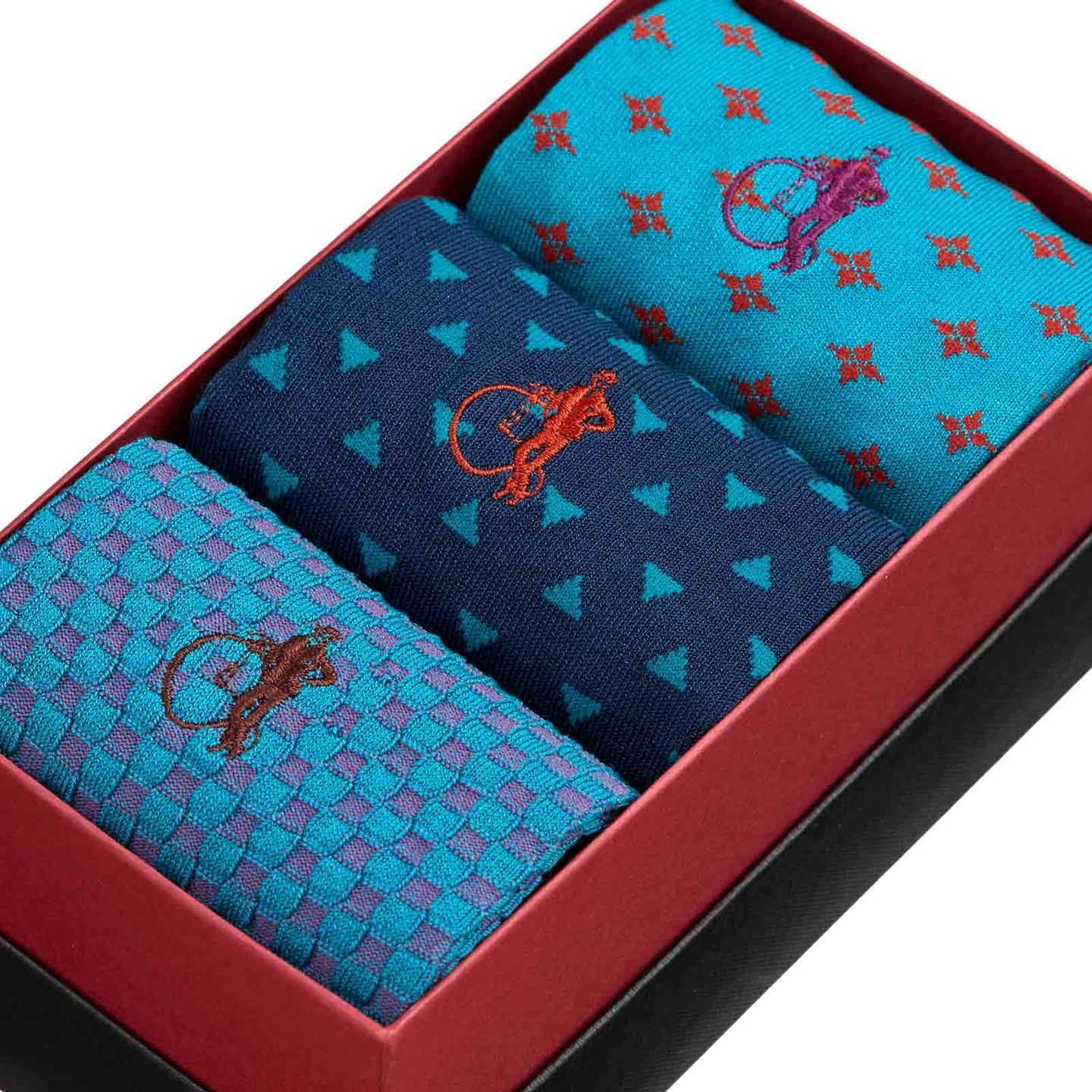 Close up of a trio sock presentation box of all blue and patterned hues