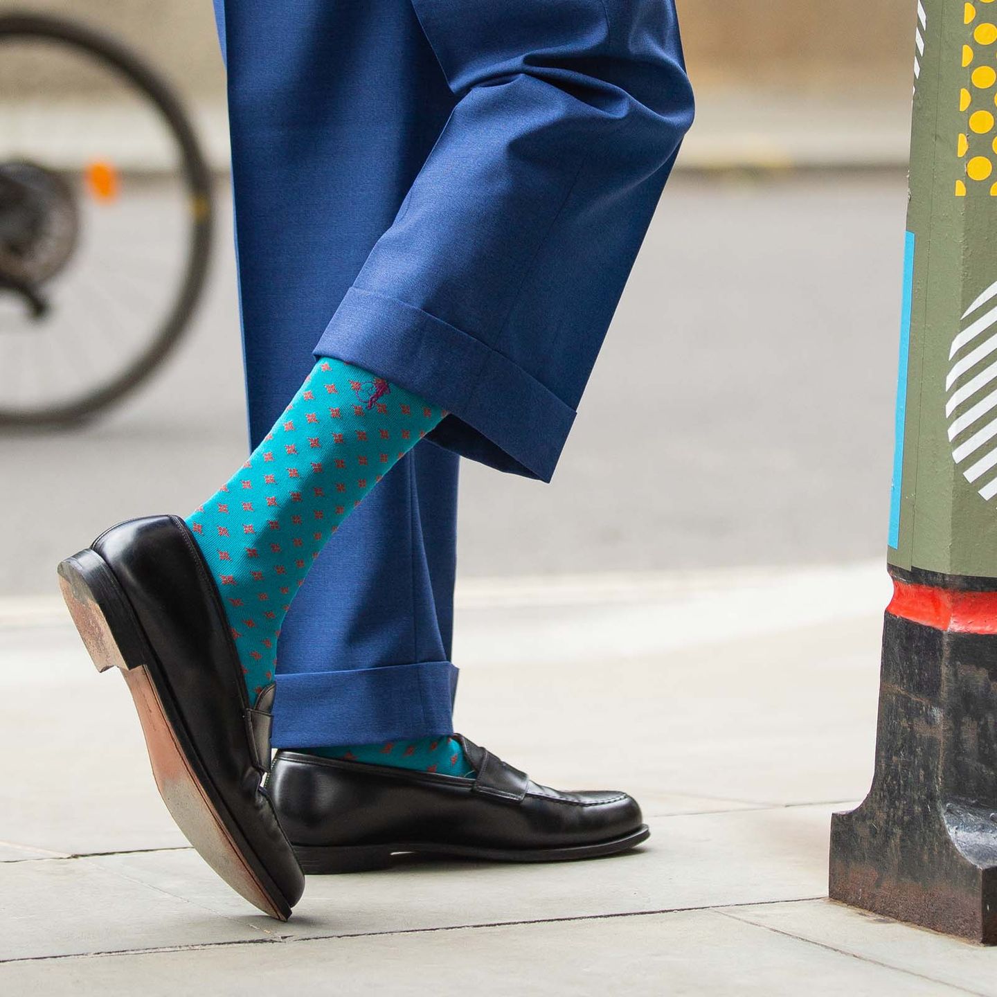 A close up of a person wearing blue and red patterned socks