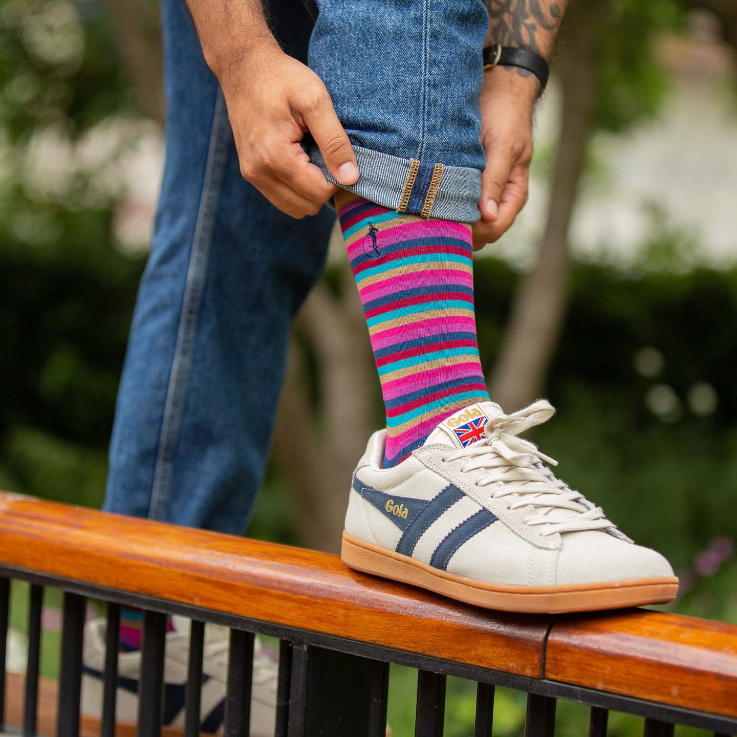 A close up of a person wearing a multicoloured sock