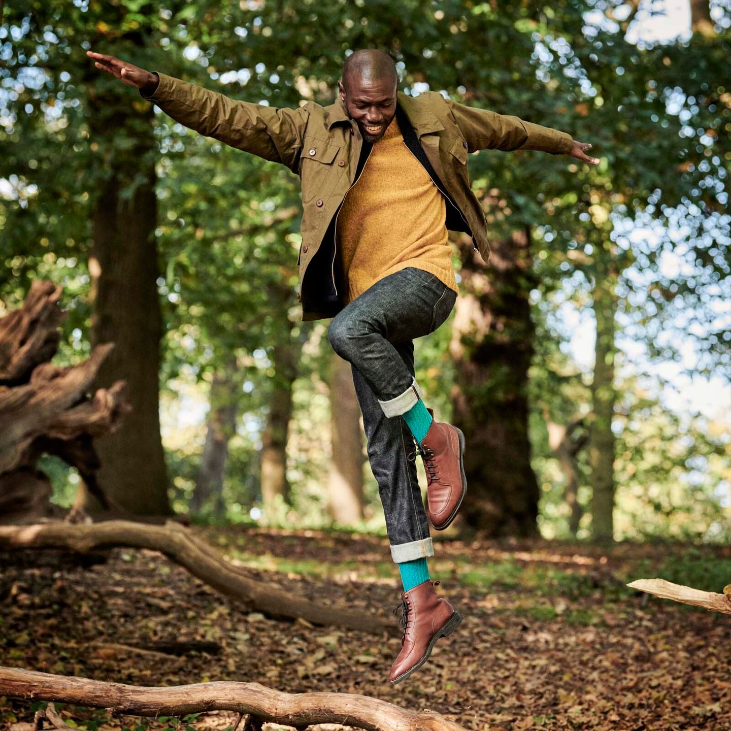 Ben Harris leaping in forest and wearing turquoise boot socks