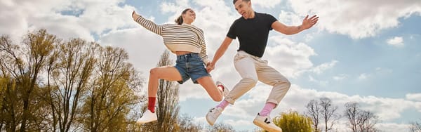 Man and woman leaping in joy wearing red and pink socks