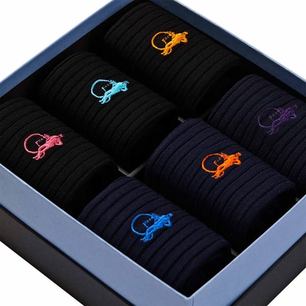 A close up of a box of long black socks for men.