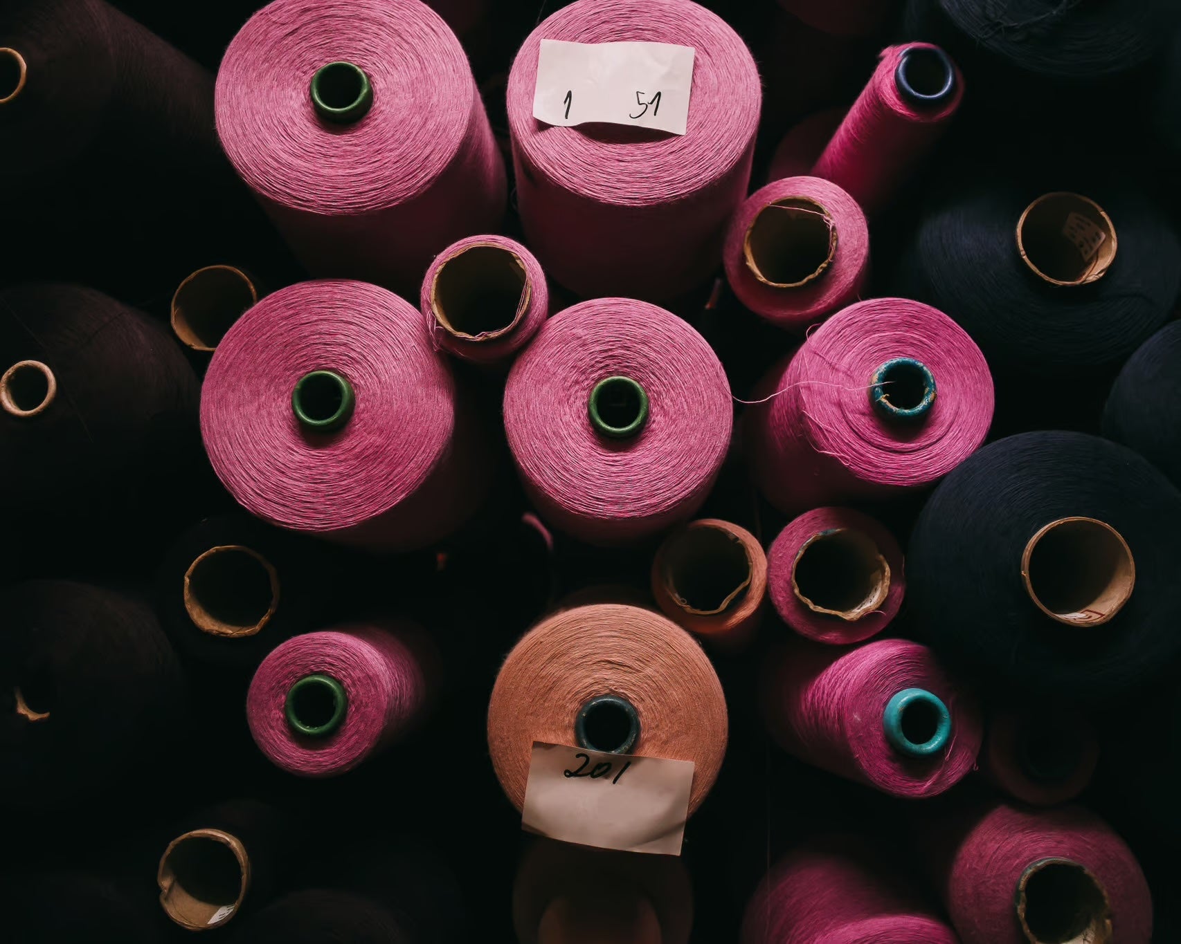 Multiple spools of black and pink thread from an aerial shot