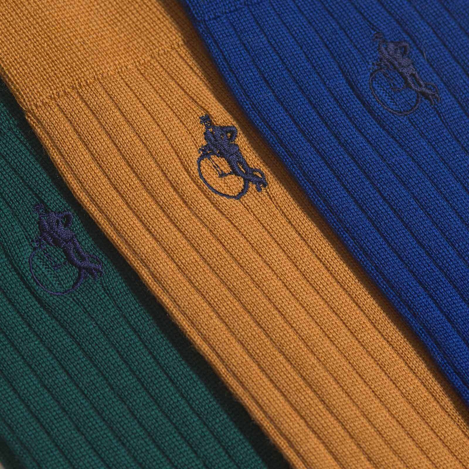 Close up of merino socks in dark green, yellow and royal blue