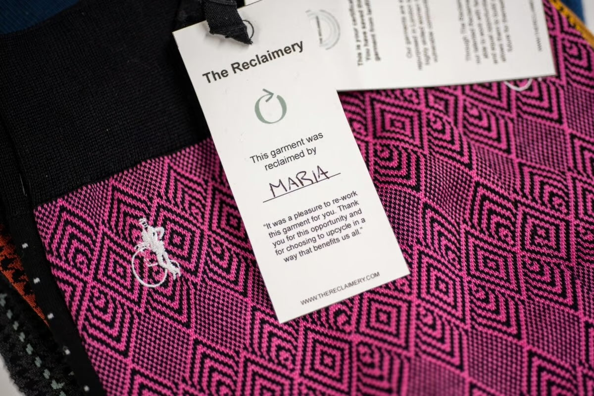 A Reclaimery garment that is pink with multiple geometric patterns in black