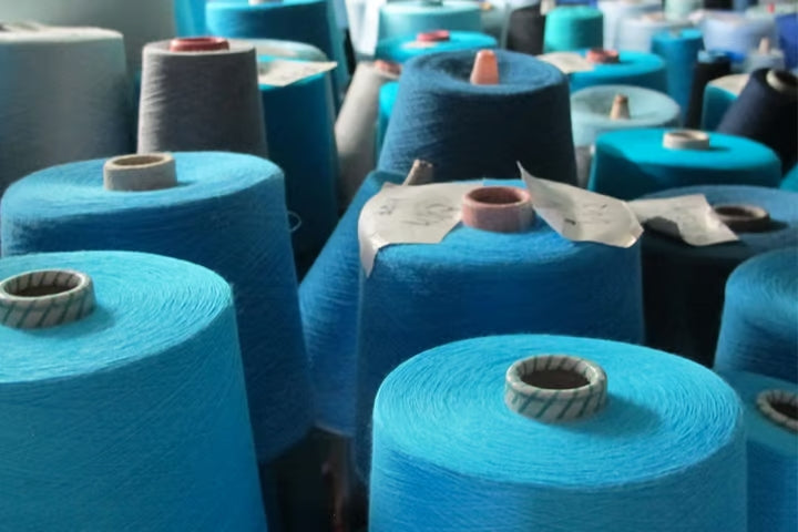 Close up of multiple spools of various blue threads