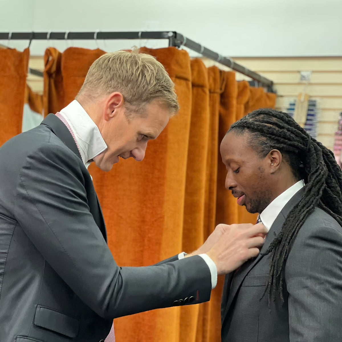 Dan Walker adjusting the tie of a user of the suited and booted charity